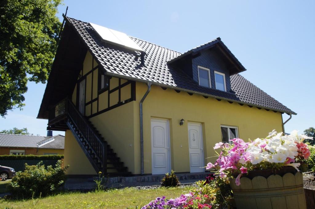 una piccola casa gialla con tetto nero di Ferienwohnungen am Roten Nil a Lübben