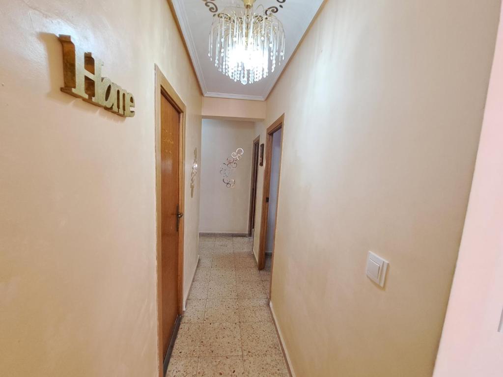 a hallway with a chandelier on the ceiling and a corridor at 3 bedroom Flat with WiFi in Valencia