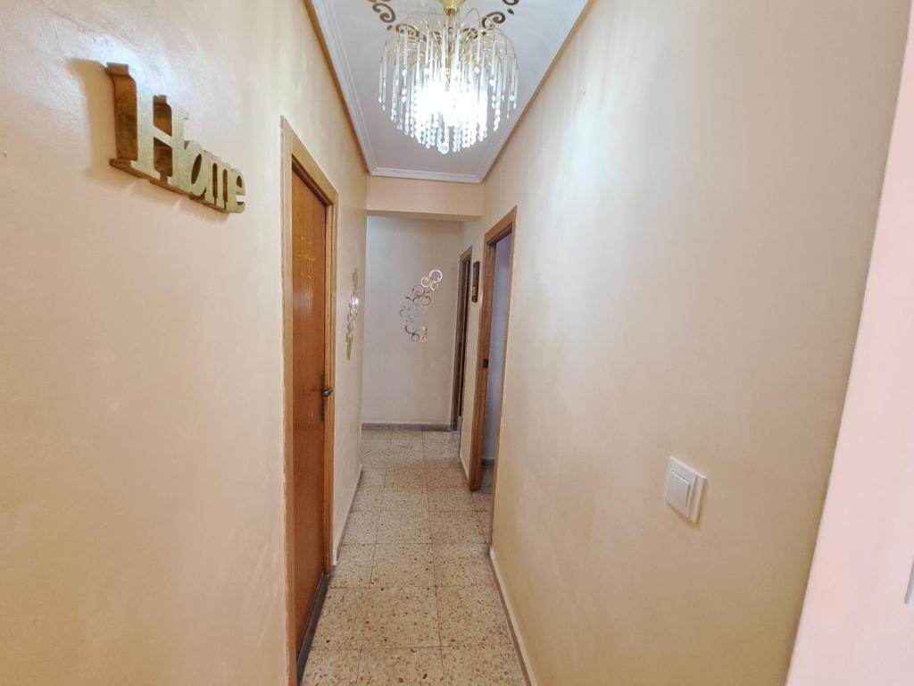 a hallway with a chandelier on the ceiling and a corridor at 3 bedroom flat with wifi in Valencia