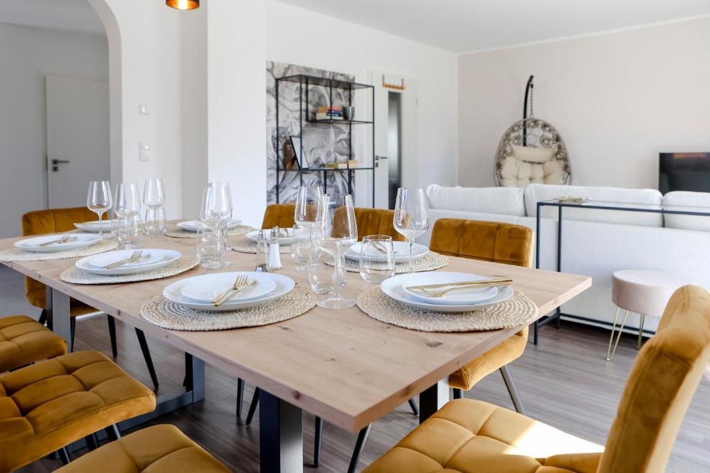 a dining room with a wooden table and chairs at Lumen Homes - Design-Apt. nahe Audi und Altstadt, 3 Zimmer, NETFLIX in Ingolstadt