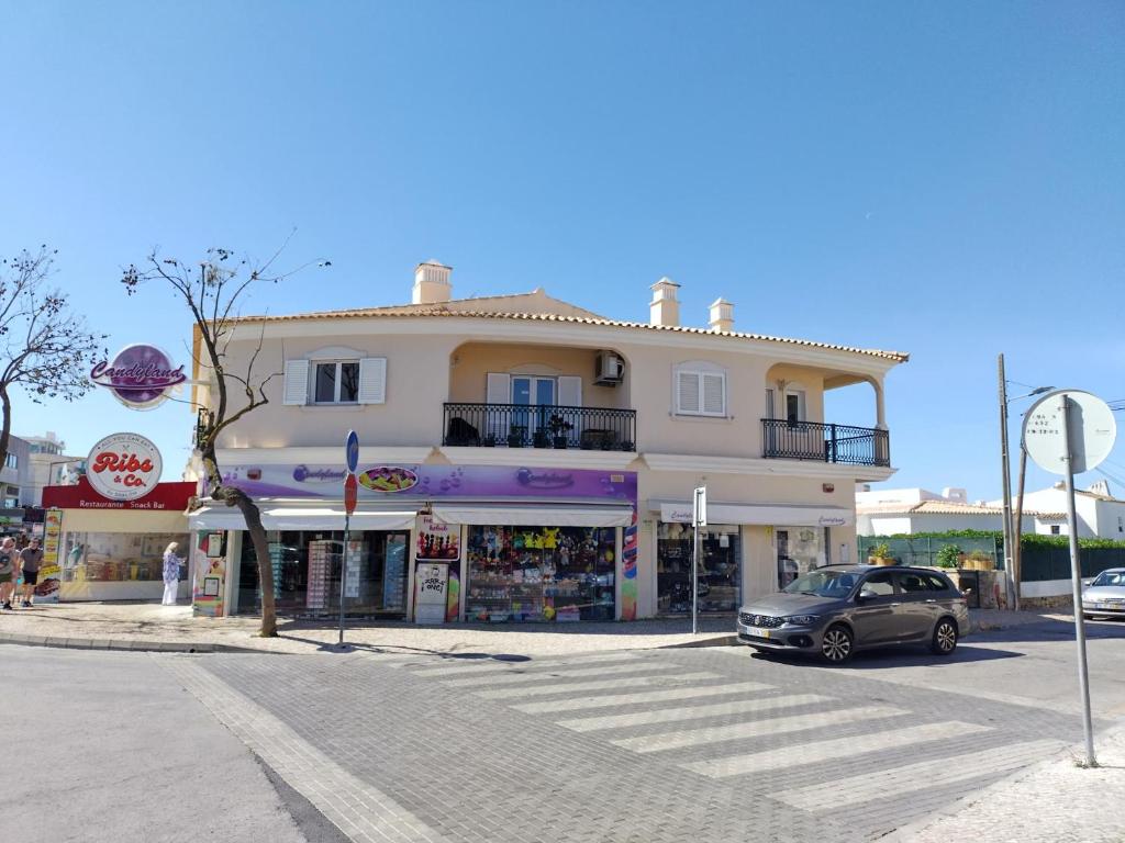 een gebouw met een auto voor een straat bij Candyland Apartment in Albufeira