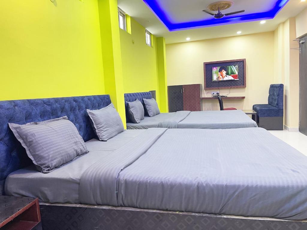 a bedroom with two beds and a couch at Hotel Seven inn by Seven Group in Puri