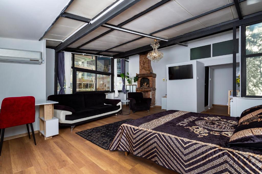 ein Schlafzimmer mit einem Bett, einem Schreibtisch und einem Sofa in der Unterkunft 8 Rooms House in Balçova