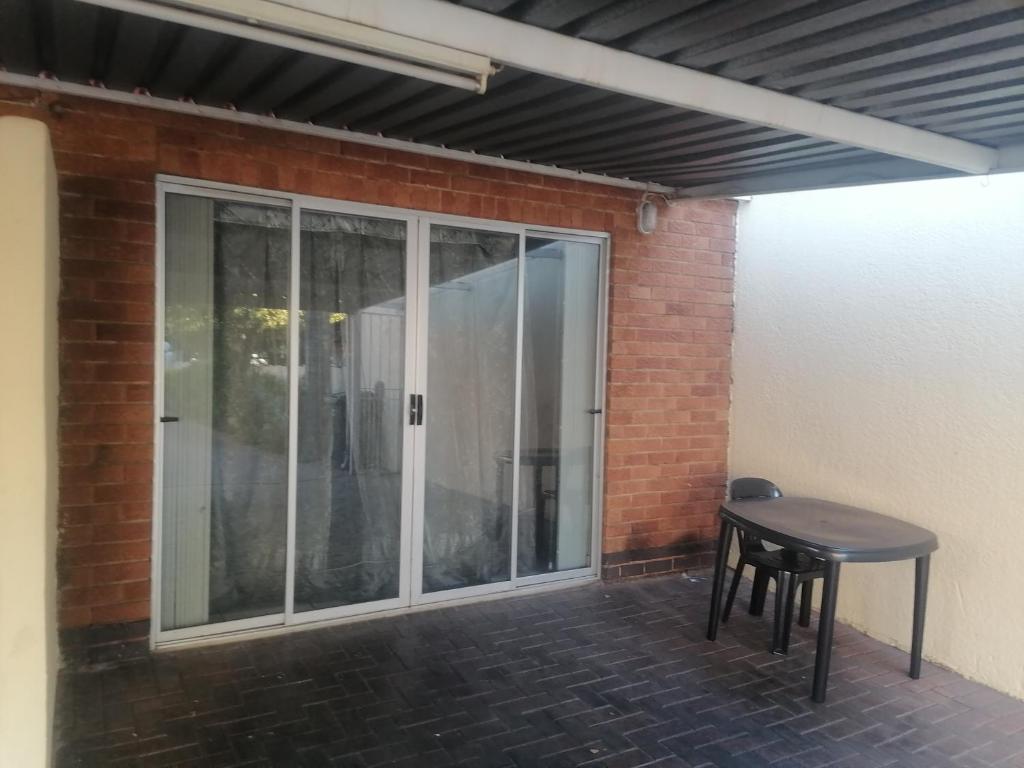 a patio with a table and a sliding glass door at Runwayghouse in Johannesburg