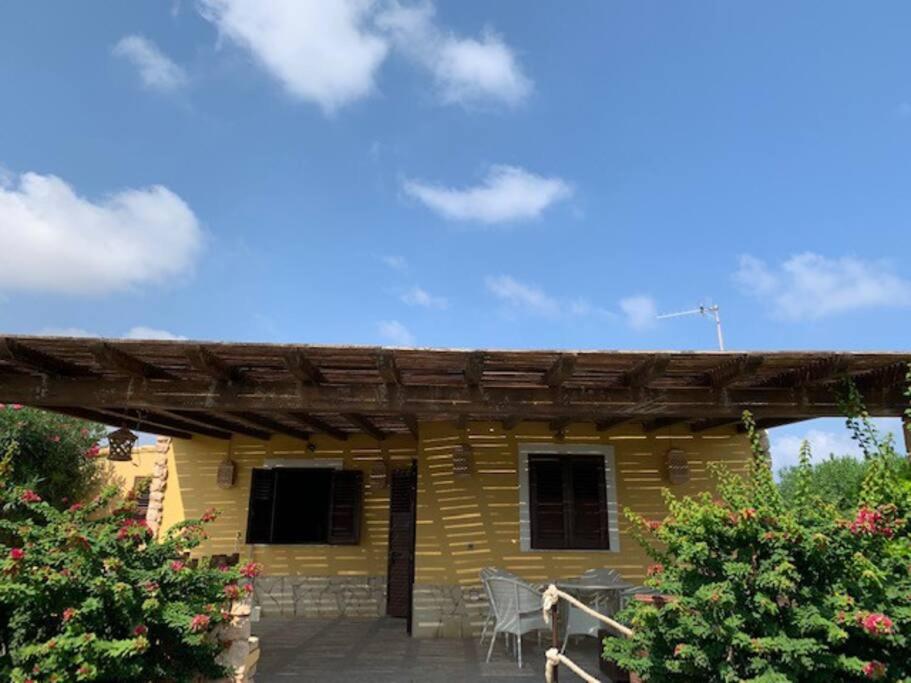 une cabane en rondins avec pergola sur une terrasse dans l'établissement Villa Maveda, un dammuso immerso nel verde, à Lampedusa