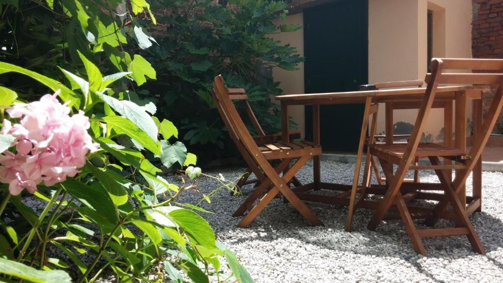 una mesa de madera y 2 sillas junto a una mesa y flores en Appartamento Corte Zappa, en Venecia