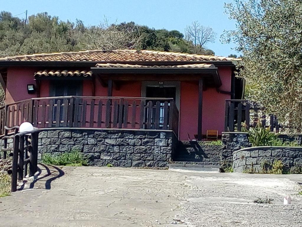 una pequeña casa roja con una pared de piedra en Rifugio Mareneve le Villette, en Linguaglossa