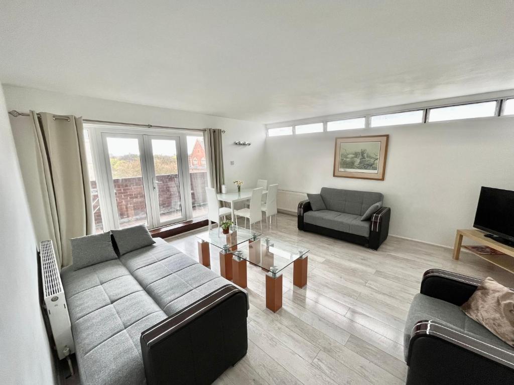 a living room with a couch and a table at Queens Way in London