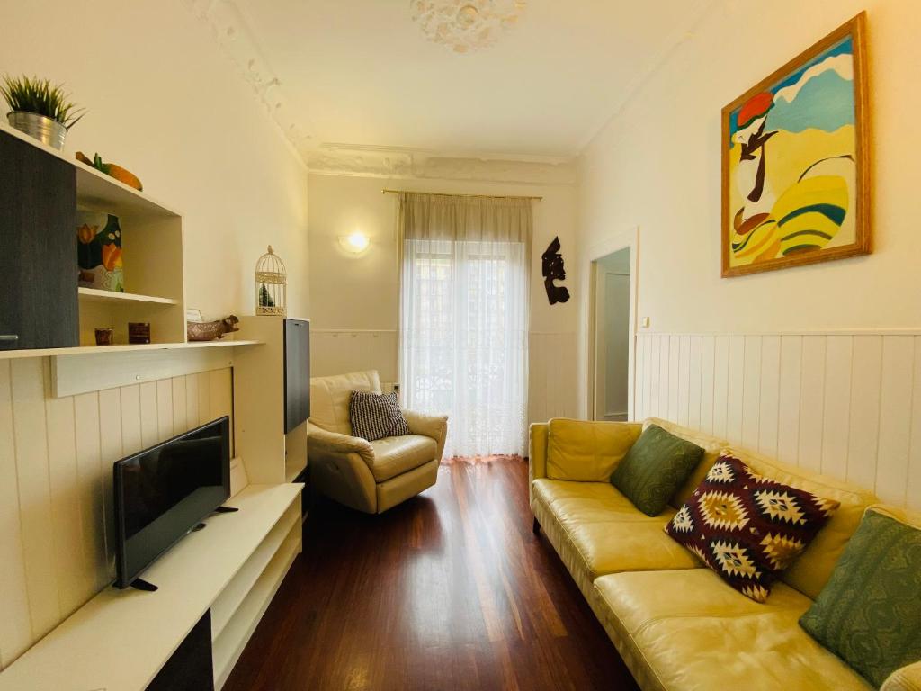uma sala de estar com um sofá e uma televisão em La plaza apartment em San Sebastián