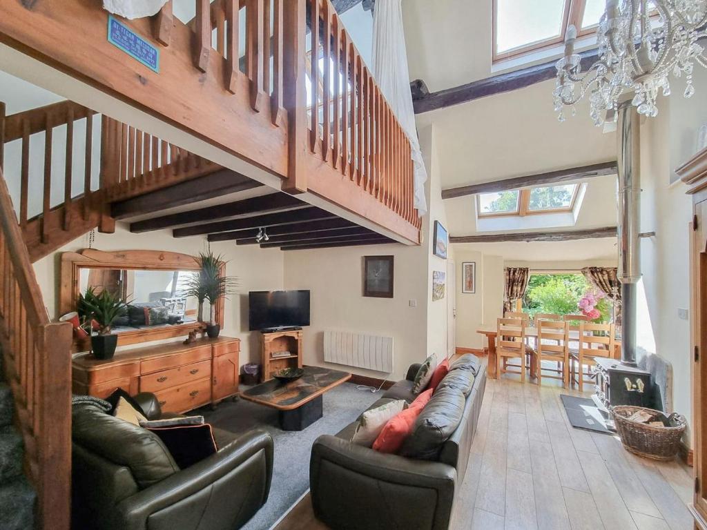 a living room with a couch and a staircase at The Gallery in Broughton in Furness