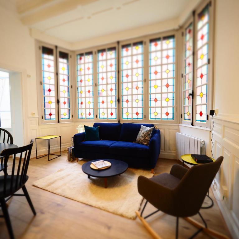 salon z niebieską kanapą i witrażami w obiekcie Appartement de charme Art Déco w mieście Vichy