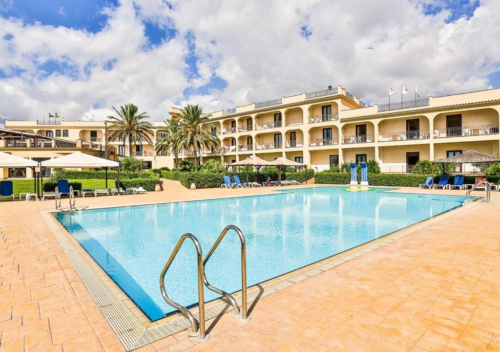 une grande piscine en face d'un hôtel dans l'établissement Grand Hotel Selinunte, à Marinella di Selinunte