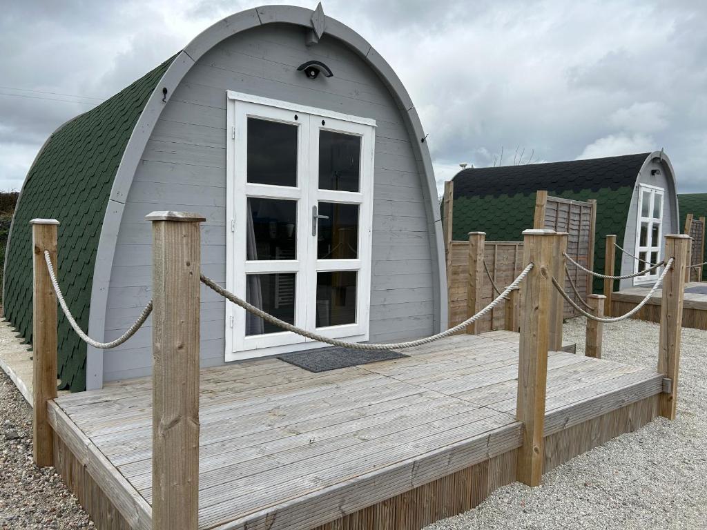 a small dome house with a wooden deck at Cosy Glamping Pod with shared facilities, Nr Kingsbridge and Salcombe in Kingsbridge