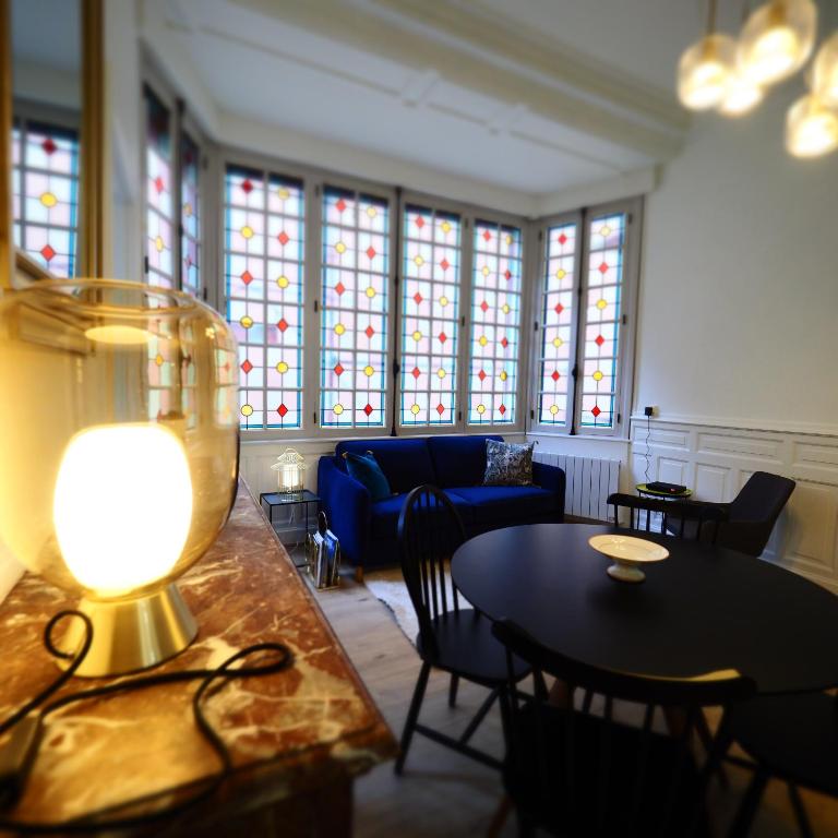 salon z kanapą, stołem i krzesłami w obiekcie Appartement de charme Art Déco w mieście Vichy