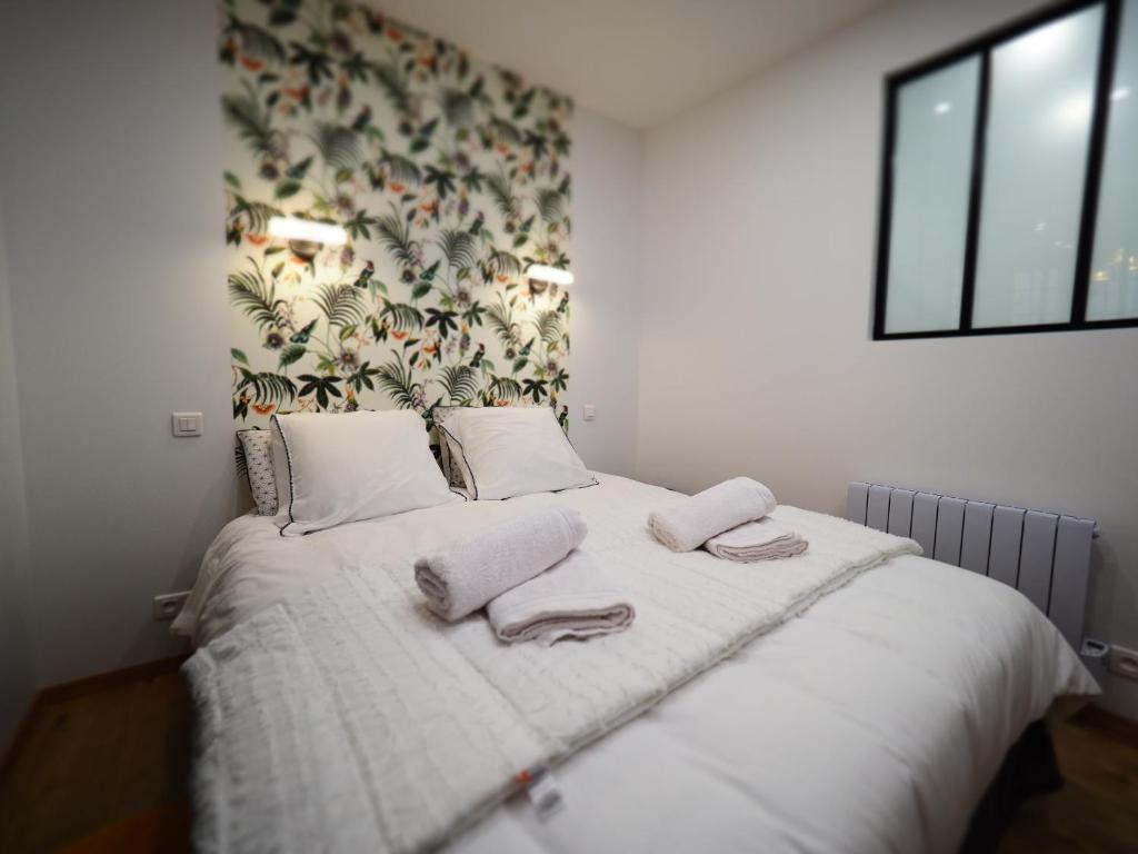 sypialnia z łóżkiem i dwoma ręcznikami na nim w obiekcie Appartement de charme Art Déco w mieście Vichy