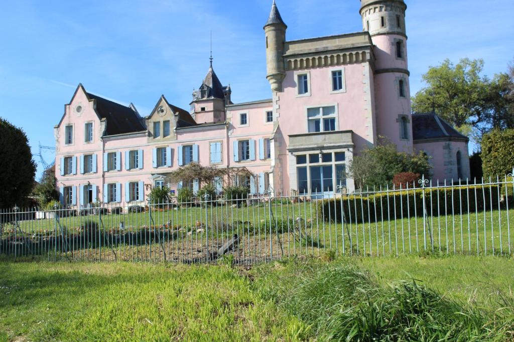uma casa velha com uma cerca em frente em Château de Villeneuve - Montolieu em Montolieu