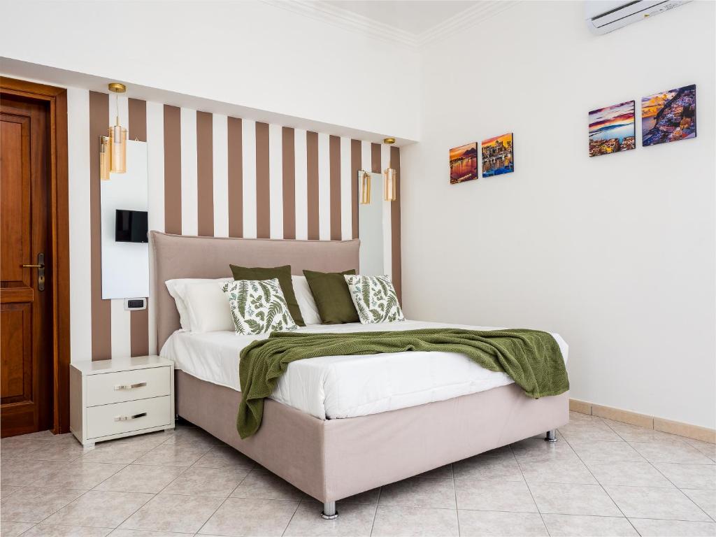 a bedroom with a bed with a green blanket on it at Palazzo Russo - De Vivo Realty Piano di Sorrento in Piano di Sorrento