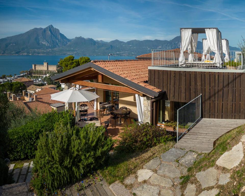 een huis met een patio en een parasol op het dak bij Residence Ca Del Lago in Torri del Benaco