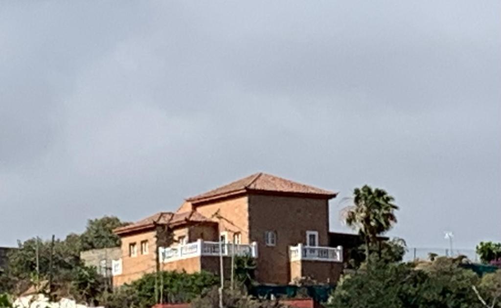 ein großes Backsteingebäude auf einem Hügel in der Unterkunft Villa Mirador Los Hoyos in Las Palmas de Gran Canaria