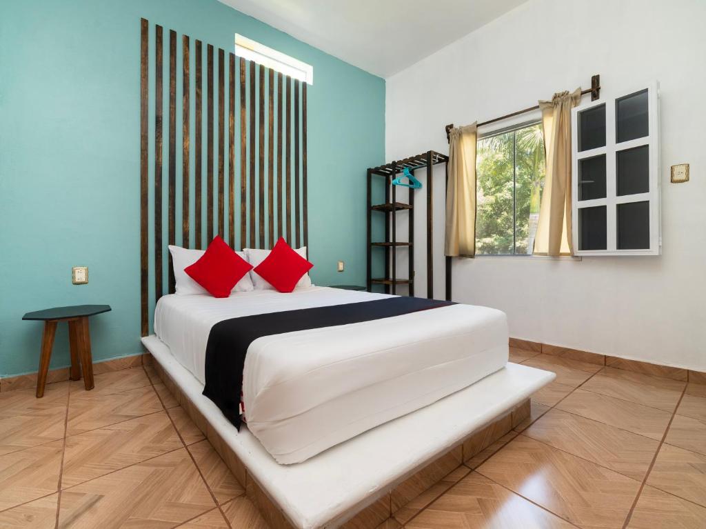 a bedroom with a large white bed with red pillows at Villas el Paraíso, El Rollo in Tlaquiltenango