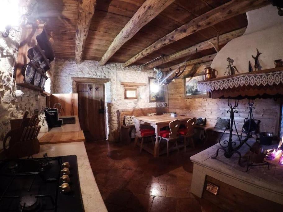 eine Küche mit einem Tisch und einem Esszimmer in der Unterkunft Chalet La Rite Dolomiti in Masariè
