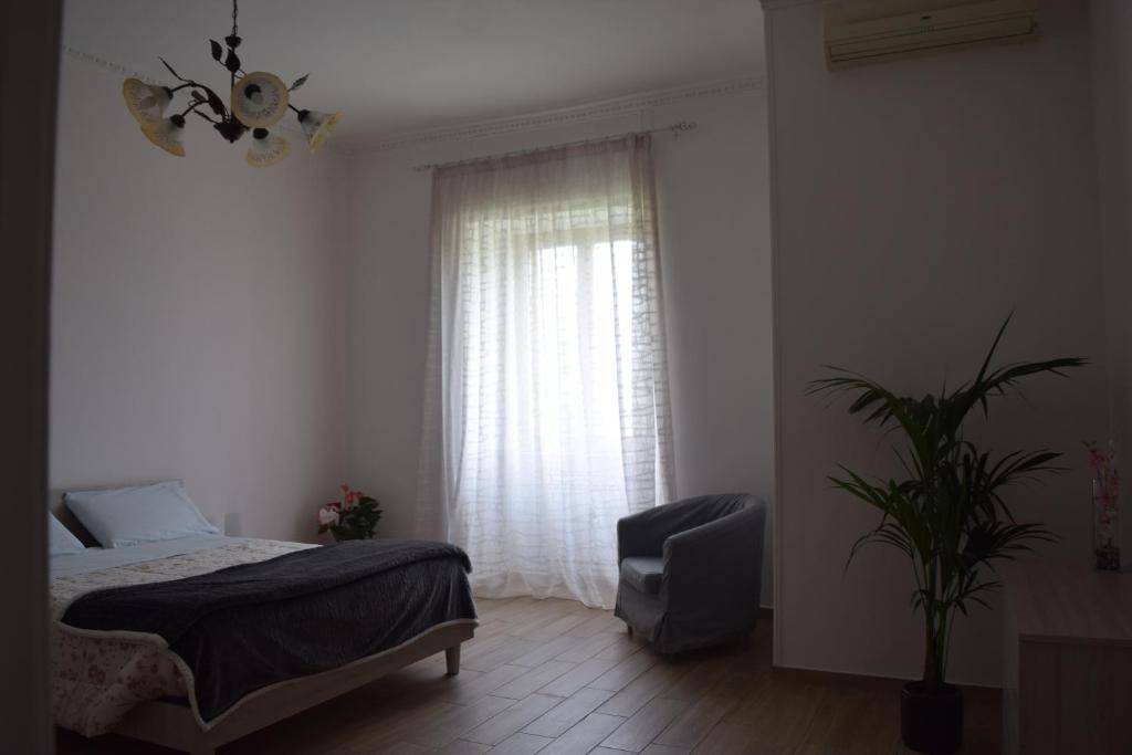 sypialnia z łóżkiem, krzesłem i oknem w obiekcie Residenza Lo Bello Vedere w mieście Caserta