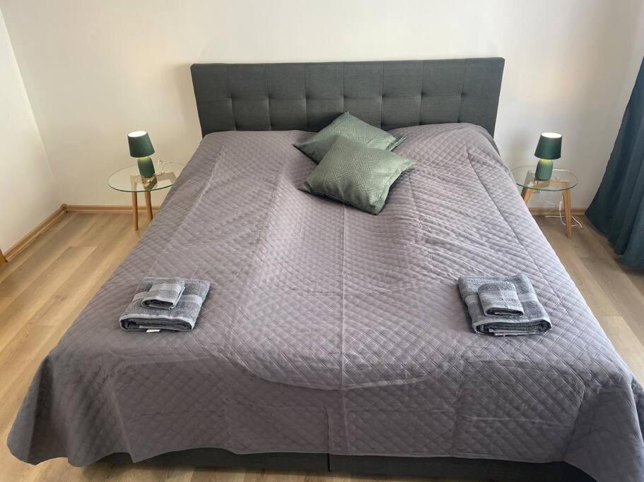 a large bed with two towels and two tables at 3 rooms apartment in Center in Ålesund