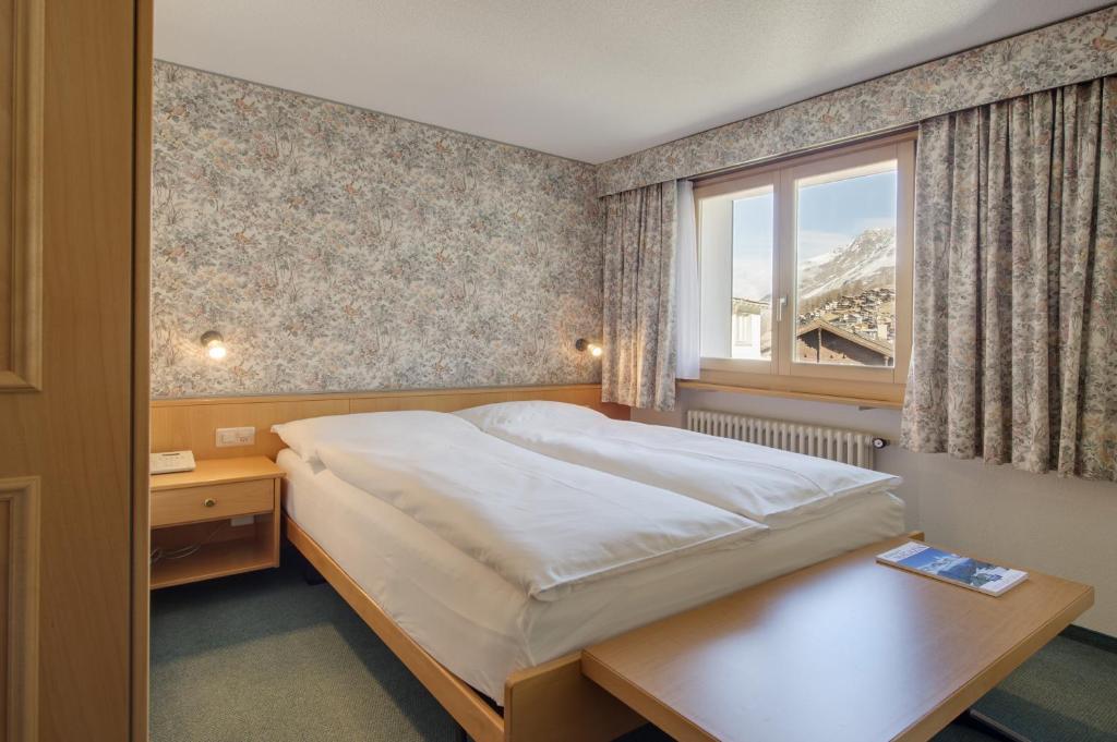 Postel nebo postele na pokoji v ubytování Hotel Metropol & Spa Zermatt