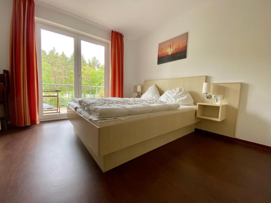 a bedroom with a bed and a large window at Küstenapartment 2 in Gelbensande