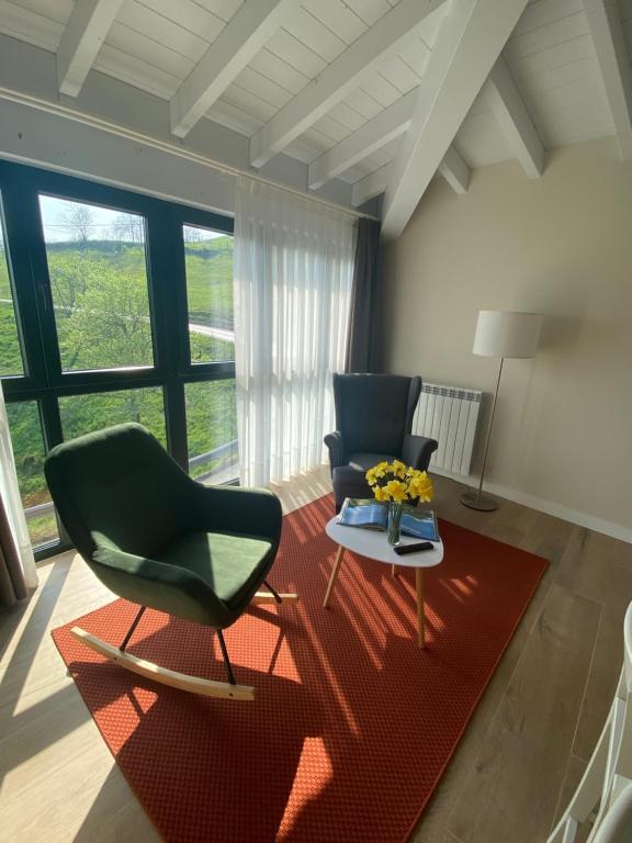 uma sala de estar com duas cadeiras e um tapete vermelho em Rincón de picos em Cangas de Onís