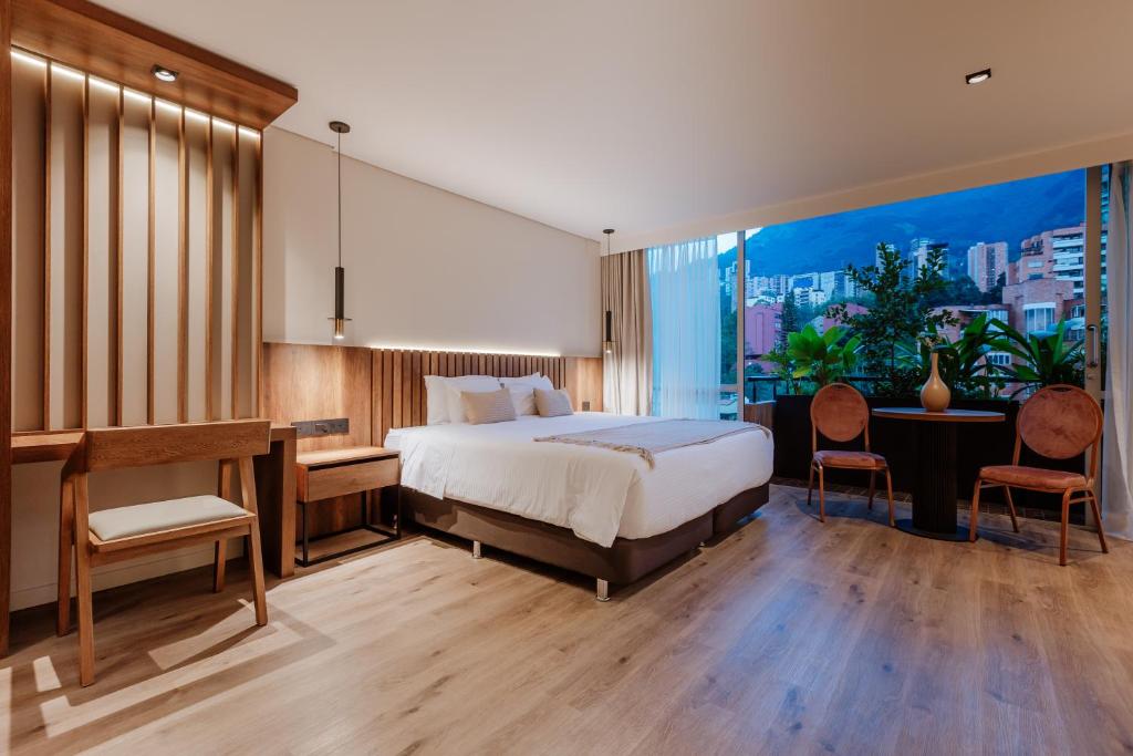 ein Hotelzimmer mit einem Bett, einem Schreibtisch und einem Schreibtisch in der Unterkunft 1616 Hotel Medellin in Medellín