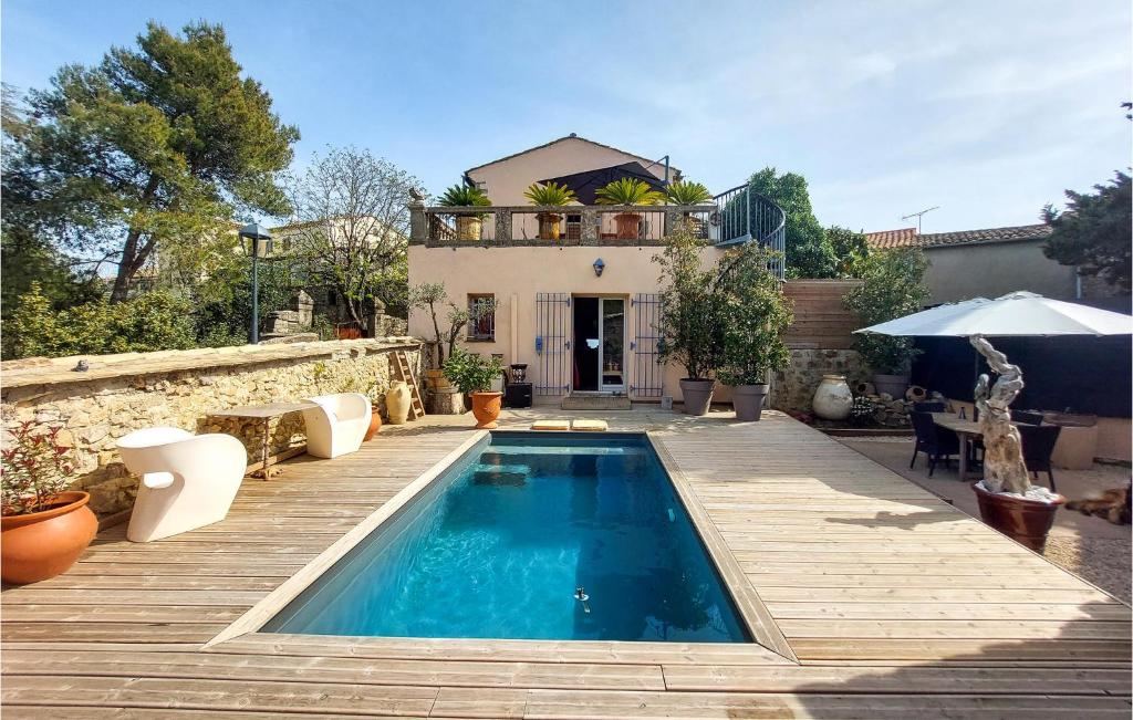une maison avec une piscine et une terrasse en bois dans l'établissement Lovely Home In Murviel Les Montpellie, à Murviel-lès-Montpellier