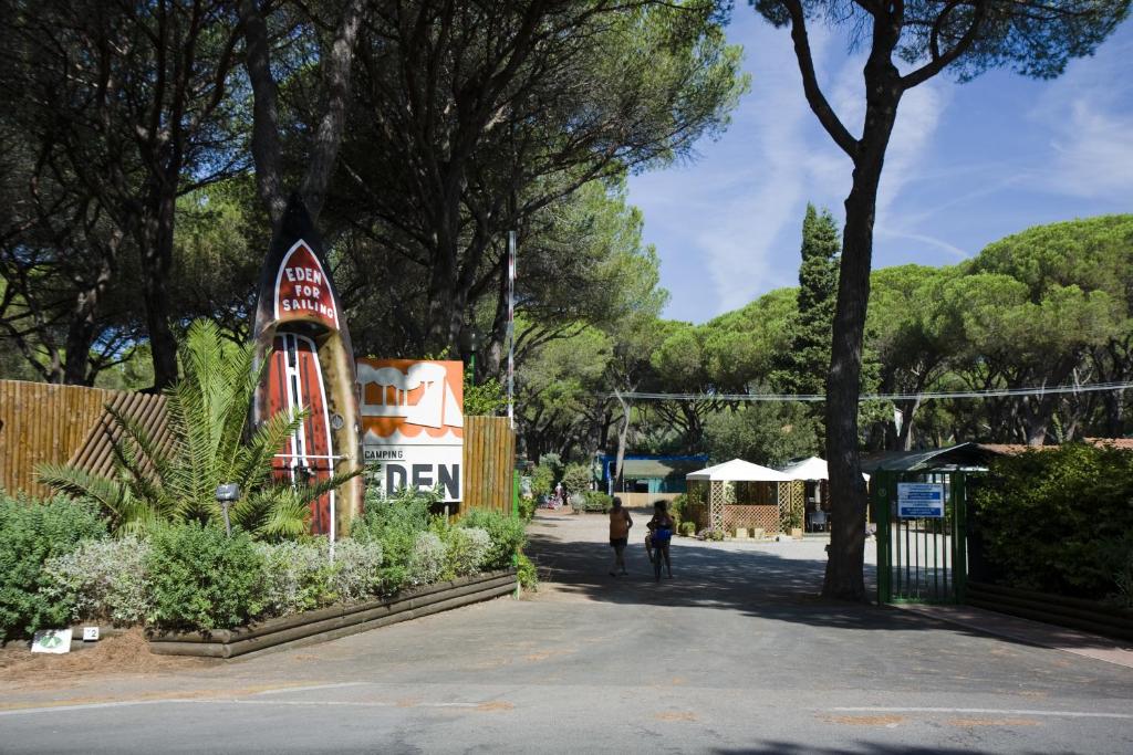 a person walking down a street next to trees at Camping Eden in Marina di Grosseto