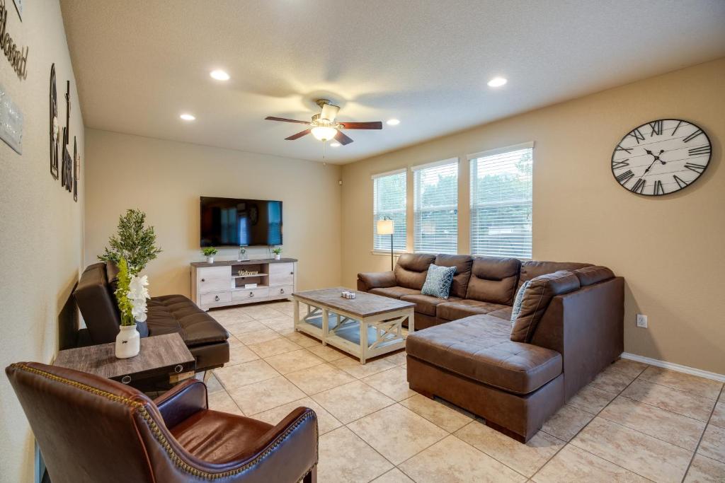a living room with a couch and a clock on the wall at San Antonio Vacation Rental with Patio Near SeaWorld in San Antonio
