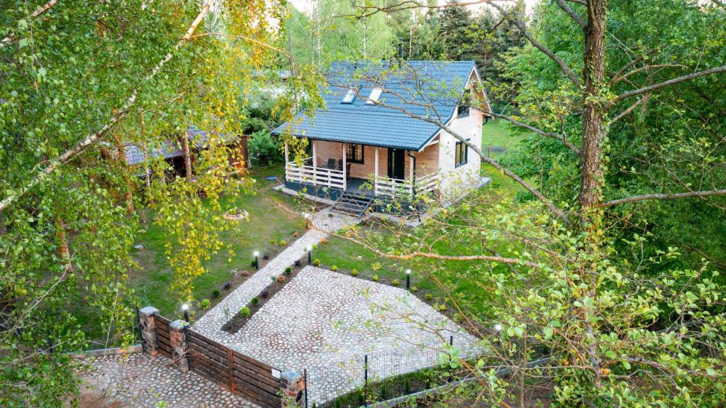Mazury domek nad jeziorem z jacuzzi في شتشتنو: إطلالة علوية على منزل ذو سقف أزرق