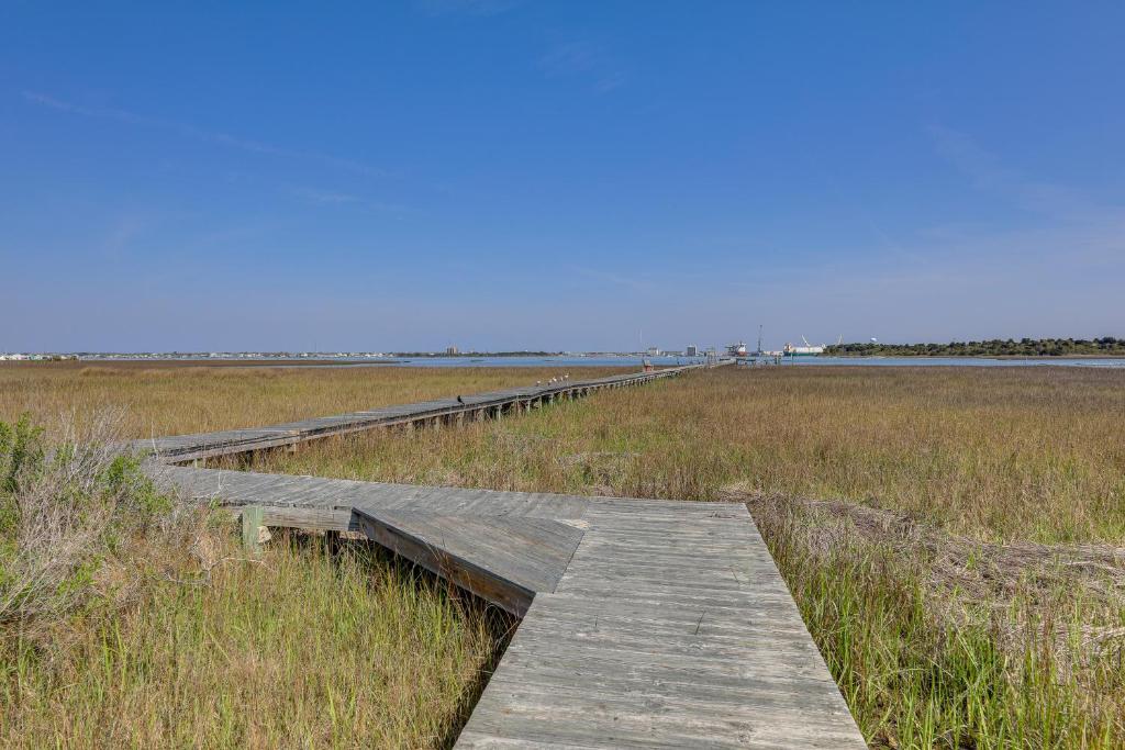 a wooden boardwalk in the middle of a field at Atlantic Beach Home By Fort Macon State Park in Atlantic Beach