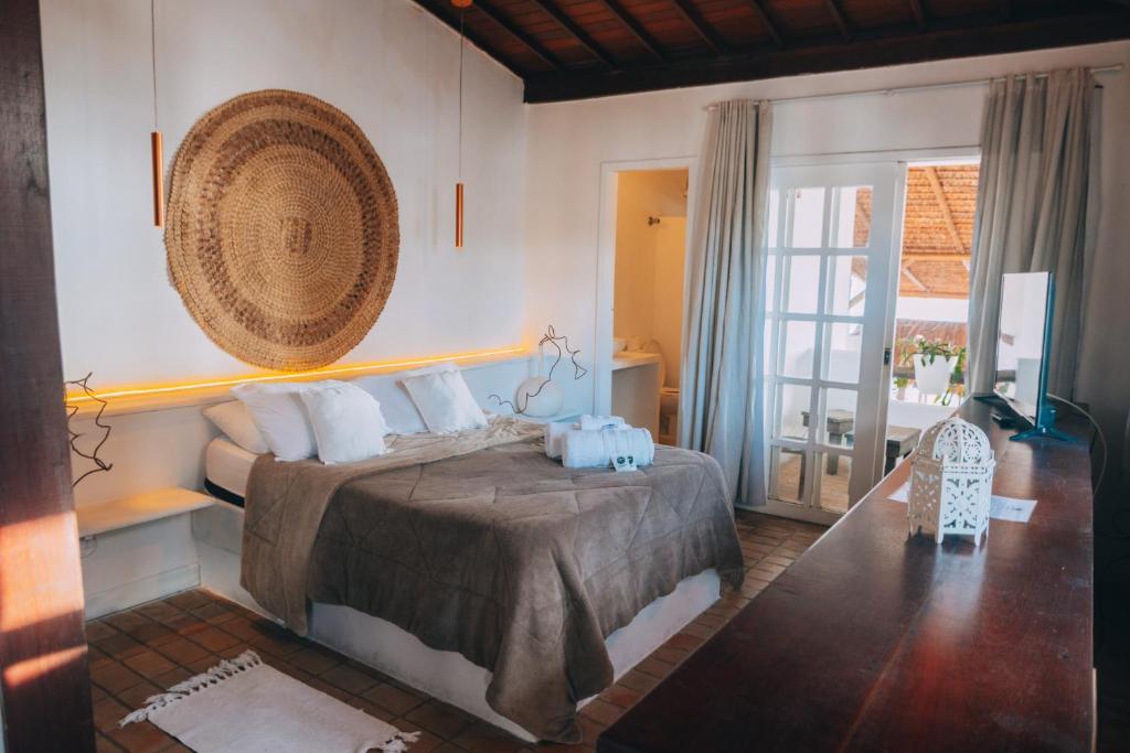 a bedroom with a bed with a basket on the wall at Agora Pousada e Bar in Pipa