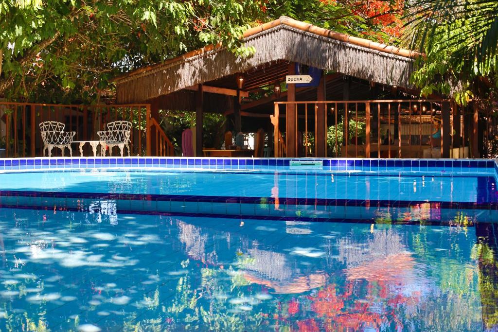 a swimming pool with a house in the background at Pousada Barbara in Pipa