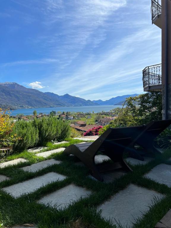 a bench on the grass with a view of the water at Villa Ago Luxury Apartments & Studios in Gravedona