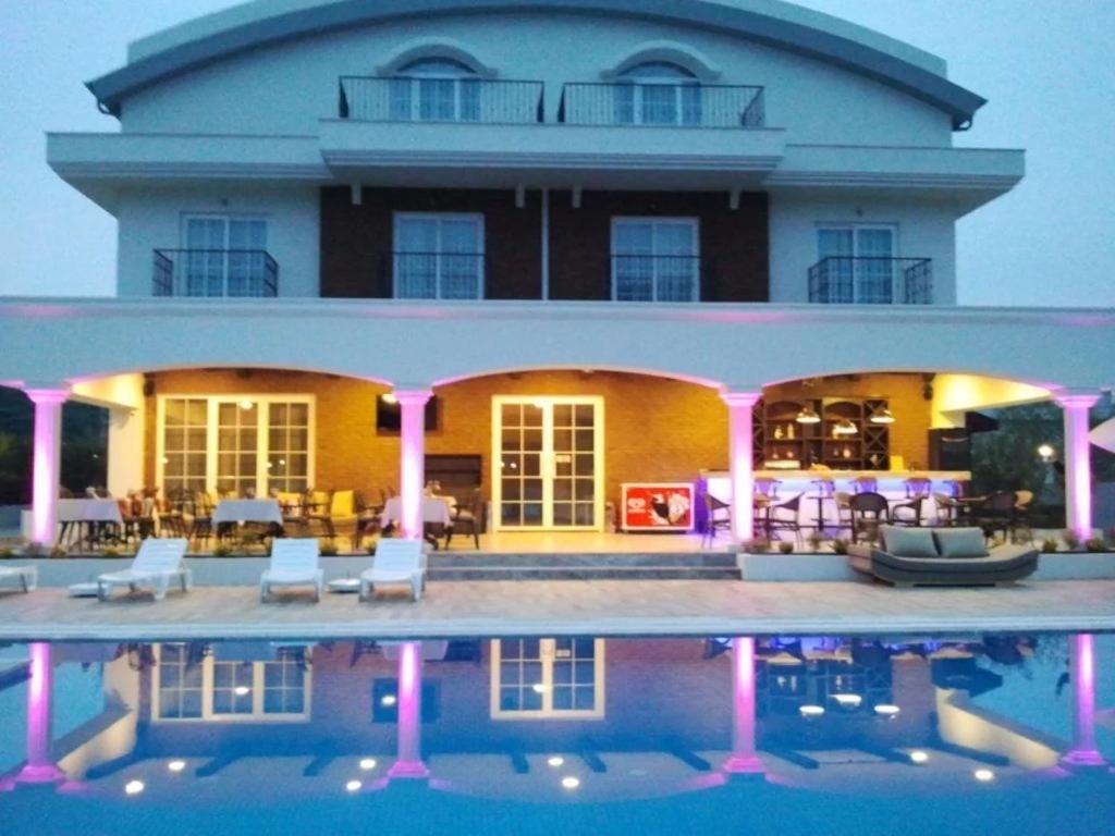 a large building with a pool in front of it at Sarban Hotel in Fethiye