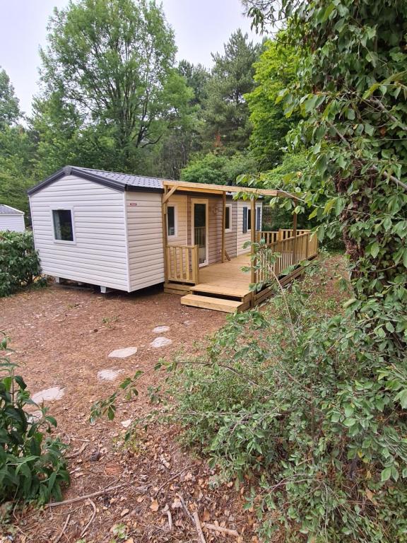 a tiny house with a porch and a deck at Mobil Home Camiers in Camiers