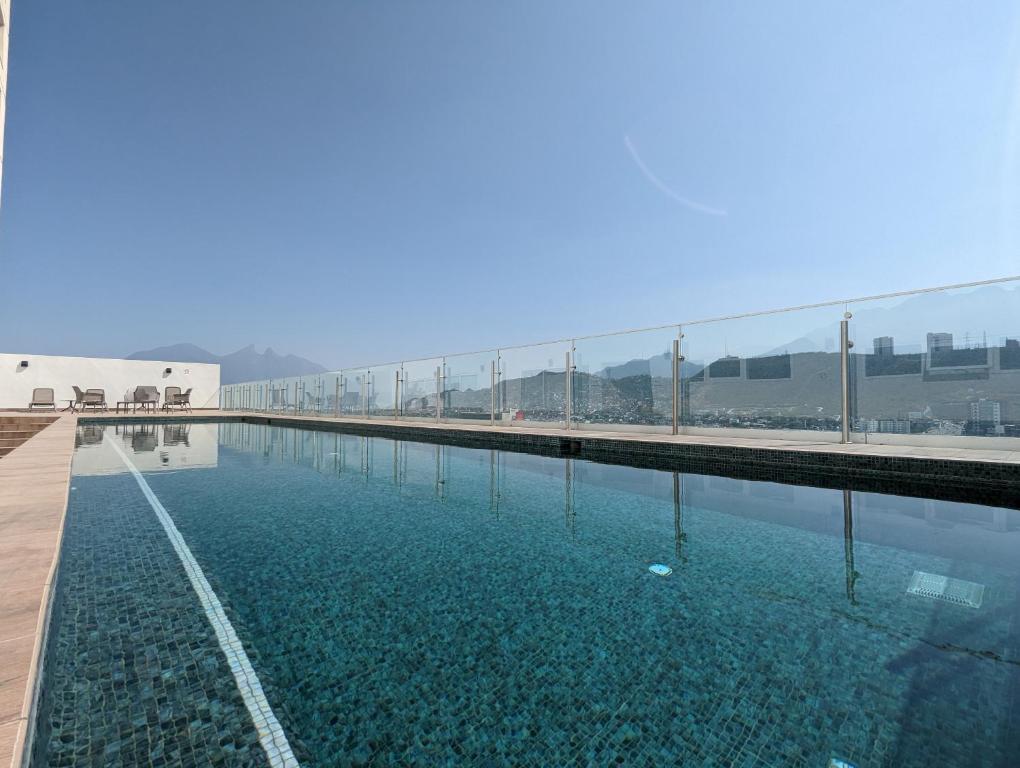 a large pool of water with a bridge in the background at Stylish Panoramic Views City Loft in Monterrey