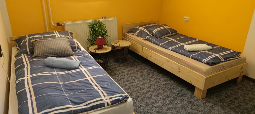 a bedroom with two beds and a table at Nagyi Vendégház Kecskemét in Kecskemét