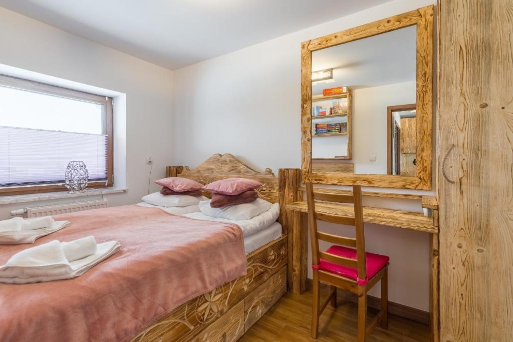 布科維納塔特贊斯卡的住宿－Baskowka Wierch Glodowski 25B B by Homeprime，一间卧室配有一张床、镜子和椅子