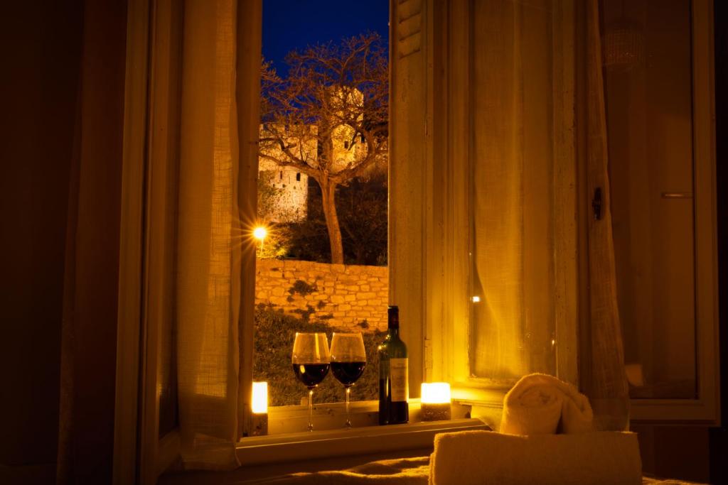 - une fenêtre avec deux verres de vin et des bougies dans l'établissement Le Pied à Terre de la Cité - Parking au Pied de la Cité, à Carcassonne