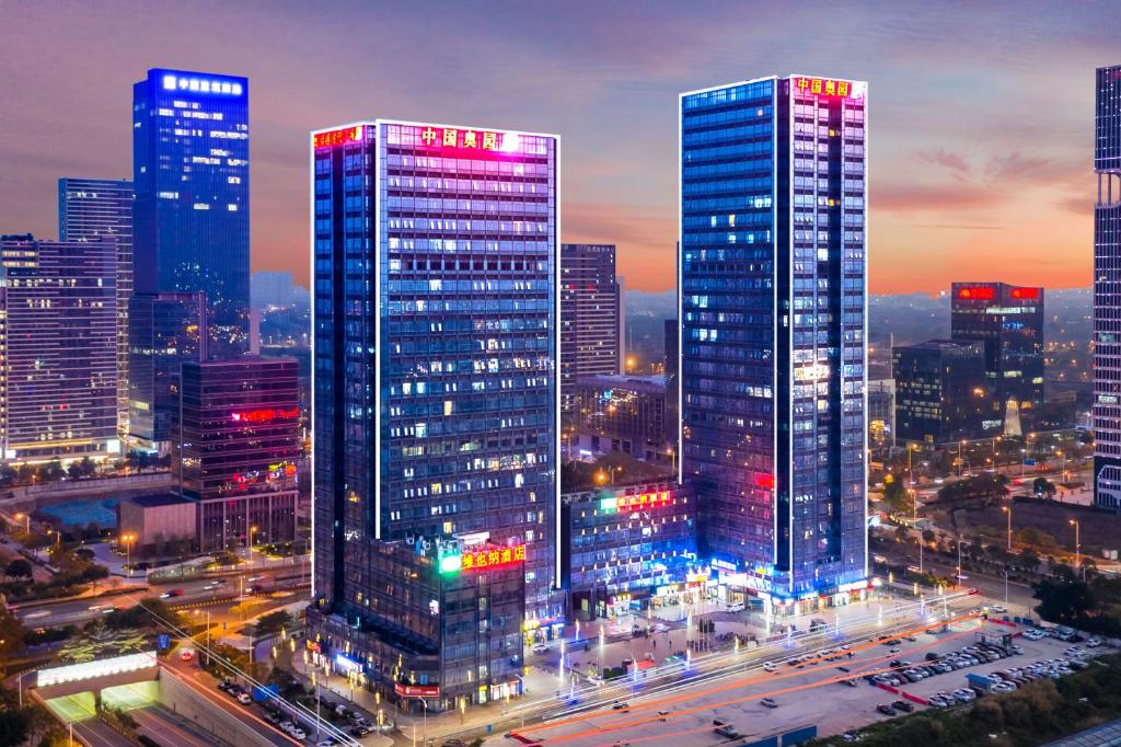 a city lit up at night with tall buildings at April Fair Duplex Apartment Guangzhou South Railway Station Ao Yuan Yue Shi Dai Branch in Guangzhou