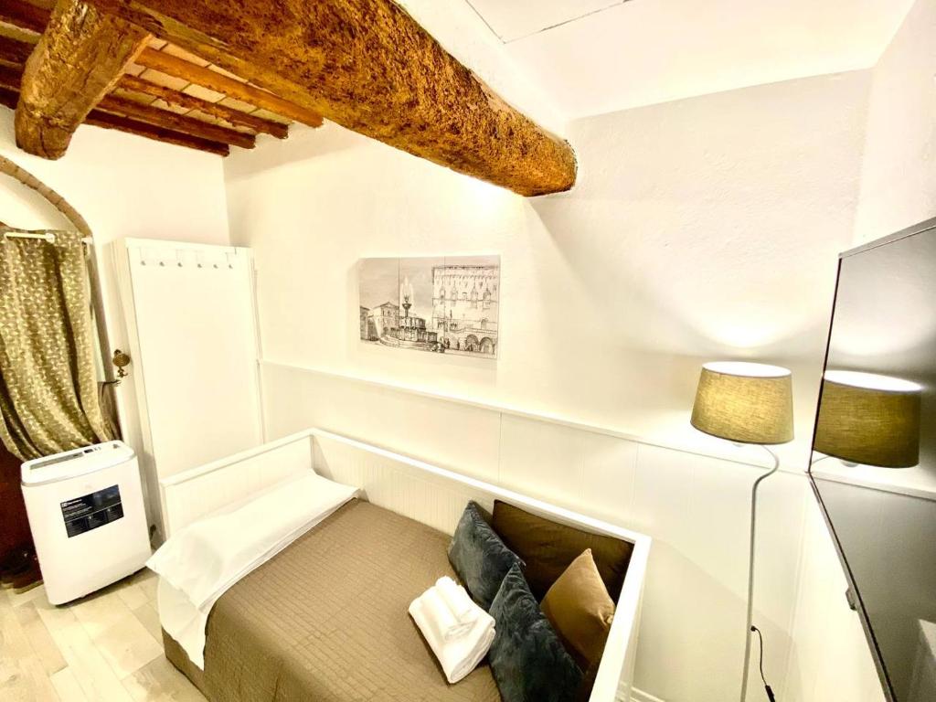 ein weißes Zimmer mit einem Sofa und einer Lampe in der Unterkunft Perugia Mini Flat in Perugia