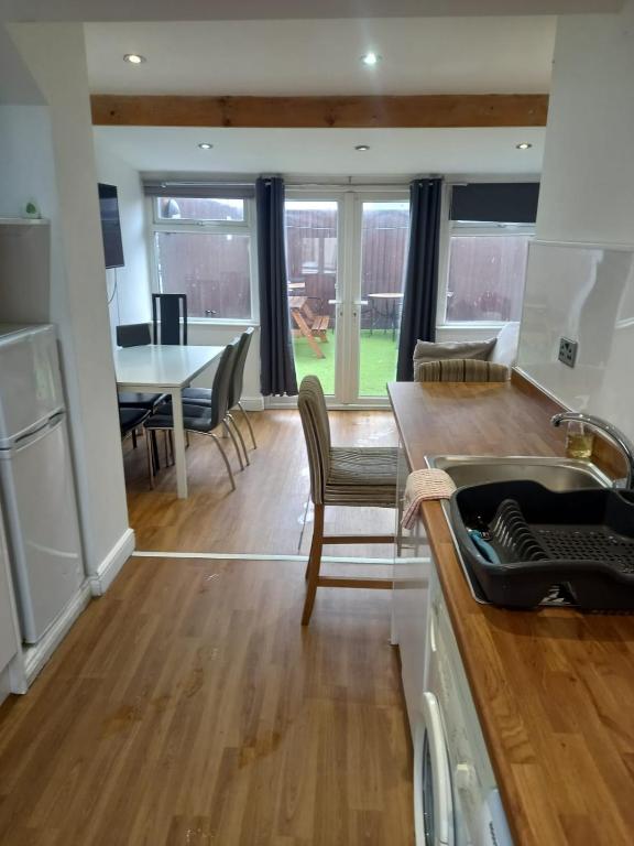 a kitchen and living room with a table and chairs at Modern Apartment with Roof Garden Close to City Centre in Cardiff
