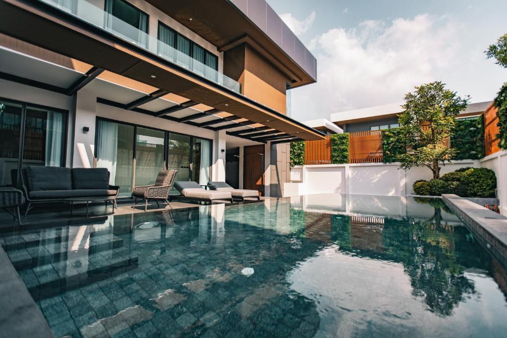 a swimming pool in front of a house at Astro Luxury: Ultra Luxury 4 Beds Pool Villa in Nong Prue
