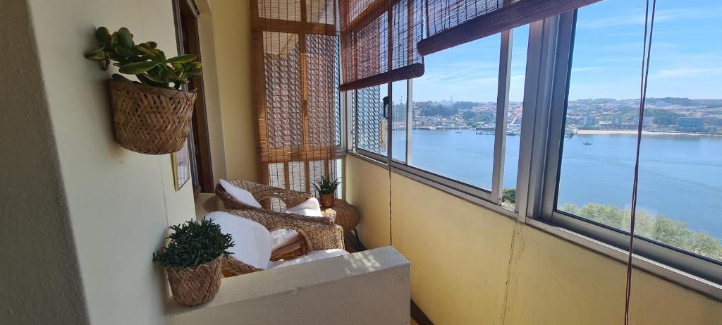 a balcony with two chairs and a view of the water at Apartamento vista Douro e Mar in Porto